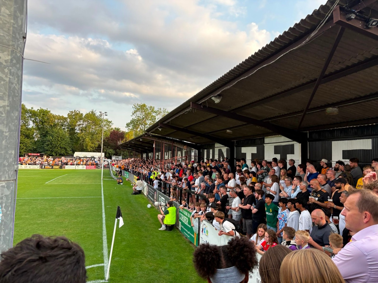 Packed terrace along the touchline at a non-league football match